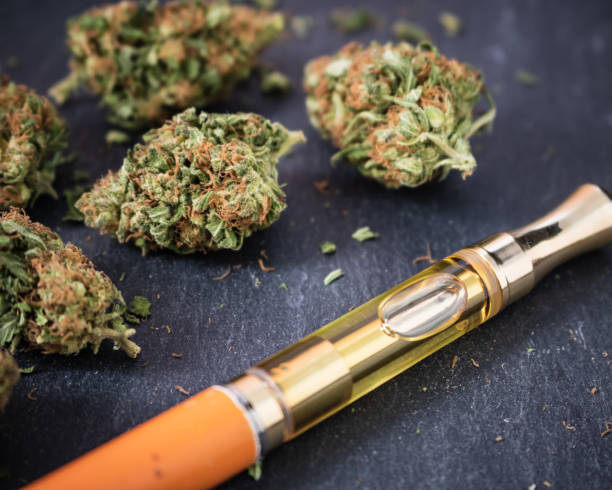 Cannabis delivery method with vape pen and flower on black background